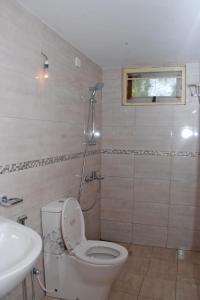 a bathroom with a toilet and a sink at Samudra Unawatuna in Galle