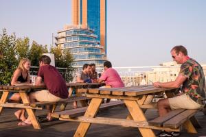 a group of people sitting at a picnic table at Marco Polo Party Hostel in St. Julianʼs