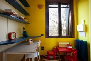 Camera gialla con tavolo, sedie e finestra di GuestHost - Cà del Frassino - Villa x5 a Gorgonzola Altre 10 foto
