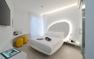 a white bedroom with a white bed and a tv at AHD Rooms in Milan
