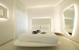 a white bedroom with a white bed and a mirror at AHD Rooms in Milan
