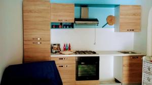 una cucina con bancone bianco e armadi in legno di Villa a vulcano a Vulcano