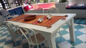 uma mesa com uma mesa branca com cadeiras e uma mesa; em Villa a vulcano em Vulcano