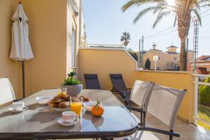 un tavolo con cibo e succo d'arancia su un balcone di Denia Las Marinas Apartamento a Denia