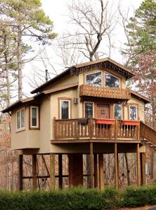 a tree house with a balcony on top of it at The Grand Treehouse Resort in Eureka Springs