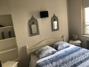 a bedroom with a bed with two mirrors on the wall at Le Charmant Zola Hyper Centre classé in Troyes