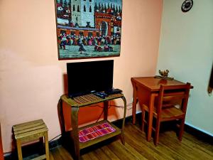a room with a desk and a laptop on a table at La Nuit home in Cusco