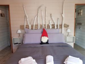 a cat wearing a santa hat sitting on a bed at Au Bois Flotté in Hourtin