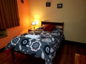 a bedroom with a bed with a black and white comforter at Hostal La Nuit in Cusco
