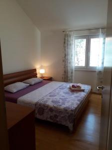 a bedroom with a large bed with a window at Marko Apartment in Korčula