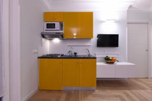 una cocina con armarios amarillos y fregadero en Angela House Amalfi centro, en Amalfi