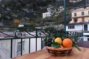 un panier de fruits posé sur une table sur un balcon dans l'établissement Angela House Amalfi centro, à Amalfi