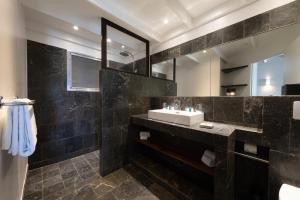 a bathroom with a sink and a mirror at Pearl Beach Hotel in Gustavia