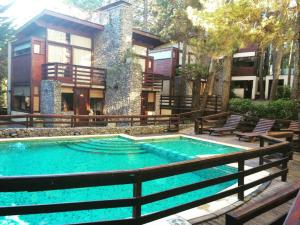 a large swimming pool in front of a building at Altos Medanos Cabañas & Club de Bosque in Mar de las Pampas