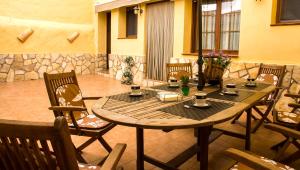 a wooden table and chairs in a patio at Casa Rural Tia Catalina in Fuentealbilla