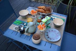 una mesa con comida y bebidas en una silla azul en Chambres d'hôtes Le Clos Bleu, en La Rochelle