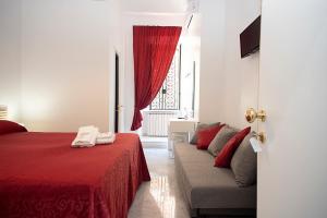 una camera con letto rosso e divano di Il Bonsai B&B a Roma