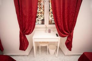 una camera con una finestra con tende rosse e un tavolo di Il Bonsai B&B a Roma