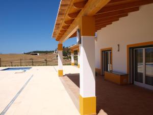 - une vue depuis l'extérieur d'une maison avec une terrasse couverte dans l'établissement Herdade dos Montes Bastos, à Santa Luzia