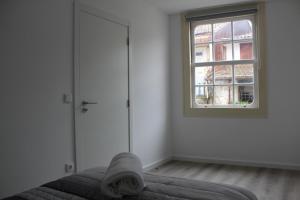 um quarto com uma cama e uma janela em University View Flat em Coimbra