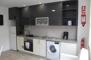 a kitchen with a washing machine and a sink at University View Flat in Coimbra