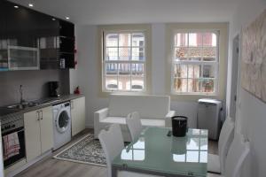 a kitchen and living room with a table and chairs at University View Flat in Coimbra