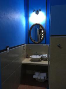 Baño azul con lavabo y espejo en Hacienda San Pedro Nohpat en Mérida