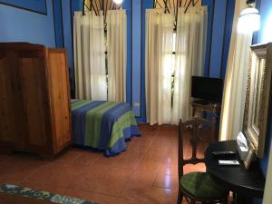 a bedroom with blue walls and a bed and a table at Hacienda San Pedro Nohpat in M&eacute;rida