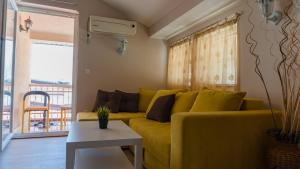 um sofá amarelo numa sala de estar com uma mesa em Di Angolo Apartments em Ohrid