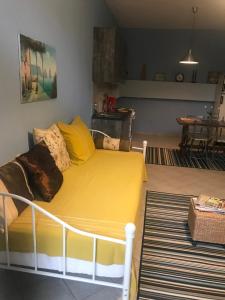 a bed with yellow sheets in a room at Sunny Garden in Plataria
