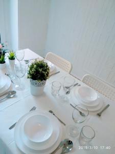 a white table with plates and glasses and a potted plant at Valencian Dreams Lonja in Valencia