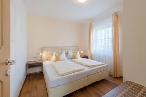 a white bedroom with a bed and a window at Ferienwohnungen Zwerger Reinhold in Termeno +39 photos
