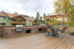 a wooden deck with a table and an umbrella at Atrium 304 in Breckenridge