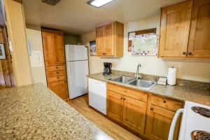 a kitchen with wooden cabinets and a white refrigerator at Columbine North Star Condo: Close To Everything in Breckenridge