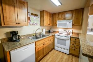 a kitchen with wooden cabinets and white appliances at Columbine North Star Condo: Close To Everything in Breckenridge