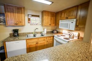 a kitchen with wooden cabinets and a white stove top oven at Columbine North Star Condo: Close To Everything in Breckenridge