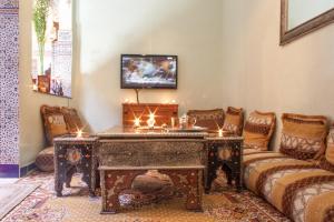 a living room with a table and a couch at Riad Mahjouba Marrakech & SPA in Marrakesh