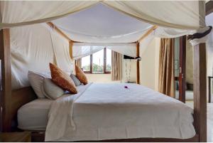 a bedroom with a white bed with a canopy at Indah Balangan Villa in Jimbaran +50 photos