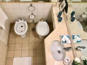 Un baño con inodoro, lavabo y urinario. en Estilo y Comodidad en Av Corrientes, departamento con cochera para autos, en Buenos Aires 17 fotos más