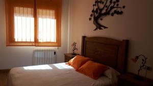 a bedroom with a bed and two windows at Casa Tere in Orihuela del Tremedal