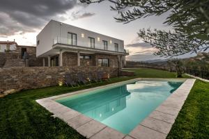 a house with a swimming pool in front of a house at Longra Family Villa & SPA in Barcel