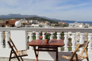 drewniany stół i 2 krzesła na balkonie w obiekcie Hotel Ronaldo w mieście Ksamil