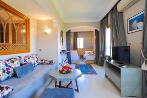 een woonkamer met een bank en een tv bij Appart-Hotel Amina Resort in Marrakesh