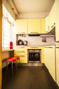 een keuken met gele kasten en rode krukken bij Luxury apartment in the heart of the capital in Kiev