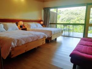 a bedroom with two beds and a couch and a window at Hotel Pibi Boreal in Alajuela City