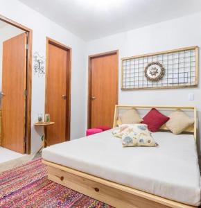 um quarto com uma grande cama branca com almofadas vermelhas em Chale´Ville Charme 501 em Luís Correia