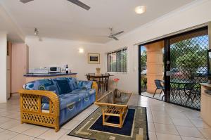 un salon avec un canapé bleu et une table dans l'établissement Central Plaza Apartments, à Cairns