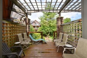 a porch with rocking chairs and a pergola at Blue Mountain-Luxurious BlueSki George Chalet, Hot Tub, Pool, Gas Fireplace in Blue Mountains