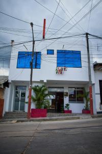 a white building with blue windows on a street at Hotel sueño Tropical in Tarapoto