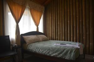 een slaapkamer met een bed en een raam met gordijnen bij SOL DE PIEDRA in Papallacta
